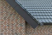 Referenz zur Inspiration für Bauherren und Planer mit J11v in spacegrau auf dem Satteldach mit Bildfokus seitlicher Dachabschluss Ortgang