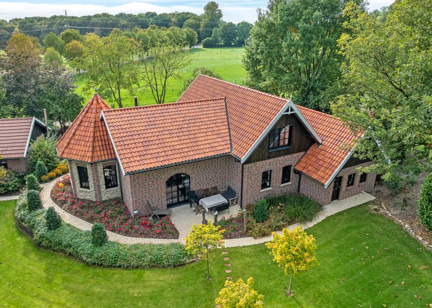 Traumhaftes Klinker-Holz-Haus mit Turm und Hohlfalzziegel Z5 in friesisch-bunt Salzbrand von Jacobi Dachziegel aus der schrägen Drohnenansicht
