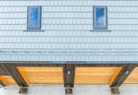 Dachziegel Stylist in edelgrau auf Holzvertäfelten Einfamilienhaus mit hochwertigem Jacobi Zubehör, Schneefanggitter, Sanitärlüfter und PV Solarträger universal fotografiert per Drohne