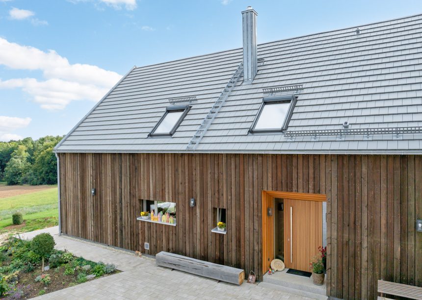 Dachziegel Stylist in edelgrau auf Holzvertäfelten Einfamilienhaus mit hochwertigem Jacobi Zubehör, Schneefanggitter, Sanitärlüfter und PV Solarträger universal
