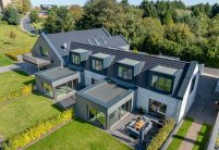 Verklinkerter Vierseitenhof mit Dachziegel, Flachziegel Stylist in samtschwarz per Drohne mit Fokus Wintergarten