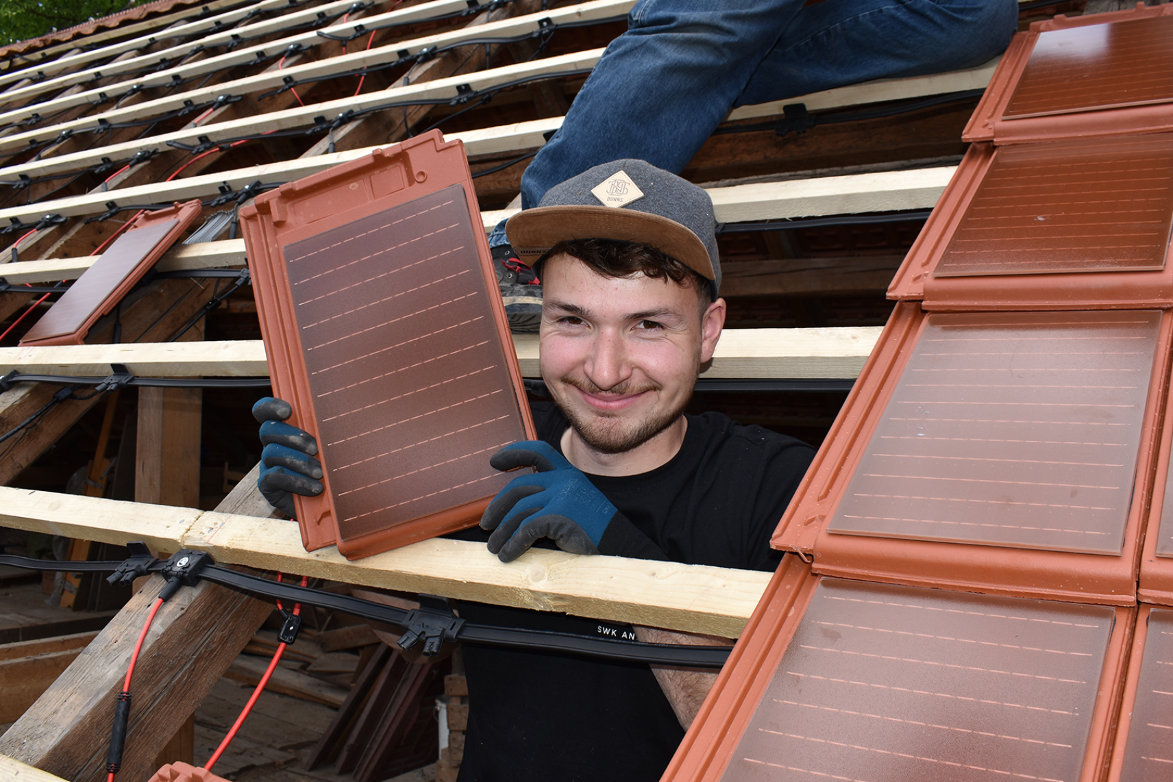 Dachdecker verlegt Solardachziegel auf Dach
