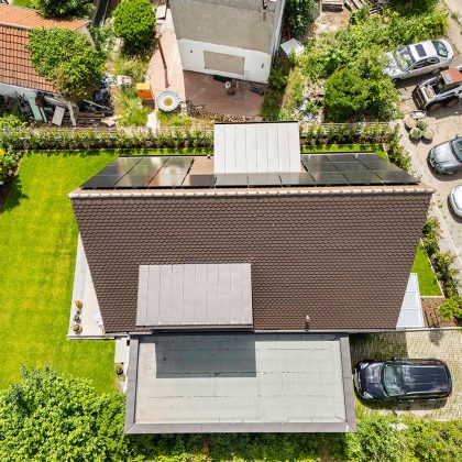 Referenz zum inspirieren mit dunkelbraunen Biberschwanzziegeln in dunkelbraun auf Steildach in der Gesamtansicht mit PV-Anlage
