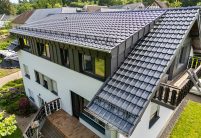 Seitliche Dachansicht mit J11v in der Glasur lavagrau matt auf einem sehr hochwertig saniertem Einfamilienhaus mit Jacobi Dachziegel Zubehör