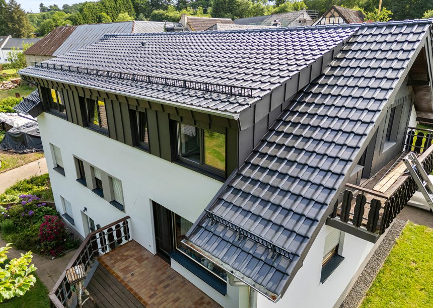 Seitliche Dachansicht mit J11v in der Glasur lavagrau matt auf einem sehr hochwertig saniertem Einfamilienhaus mit Jacobi Dachziegel Zubehör