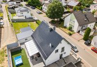 Einfamilienhaus mit blauem Dach: Neubau mit Dachziegel J13v in marineblau aus der schrägen Luftansicht