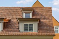 Saniertes Haus mit Biberschwanzziegel geflammt - Wellenbiber - mit frontalen Fokus auf die Schleppdachgauben