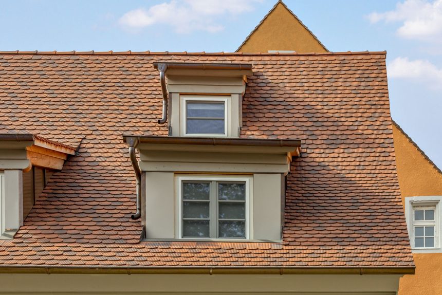 Saniertes Haus mit Biberschwanzziegel geflammt - Wellenbiber - mit frontalen Fokus auf die Schleppdachgauben