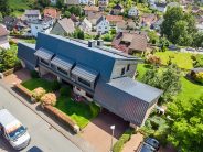 Flachdachziegel J11v spacegrau auf spektakulären Klinkerbau aus der Drohnenperspektive