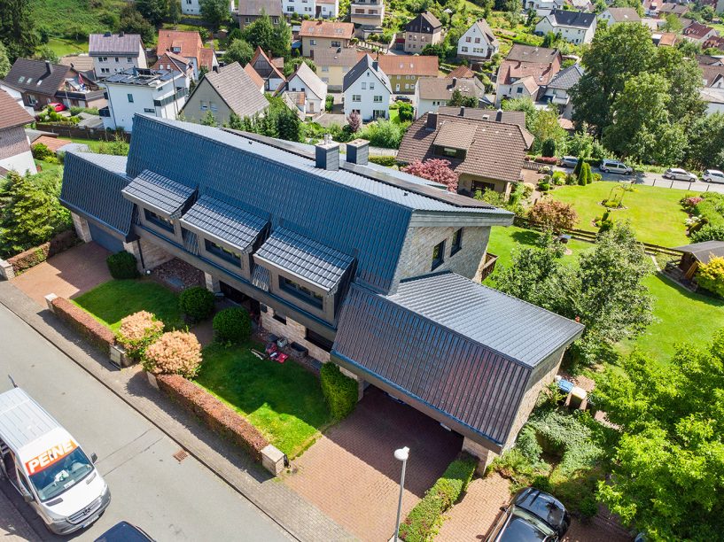 Flachdachziegel J11v spacegrau auf spektakulären Klinkerbau aus der Drohnenperspektive