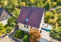 In der kompletten Ansicht mit Drohne fotografiert: J13v Flachdachziegel auf Steildach in der besonderen Oberfläche bordeauxrot
