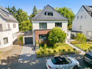 Saniertes Walmdach mit Solarziegel Stylist-PV verleiht Sanierungsobjekt neuen Glanz hier frontal mit Hof und Garage