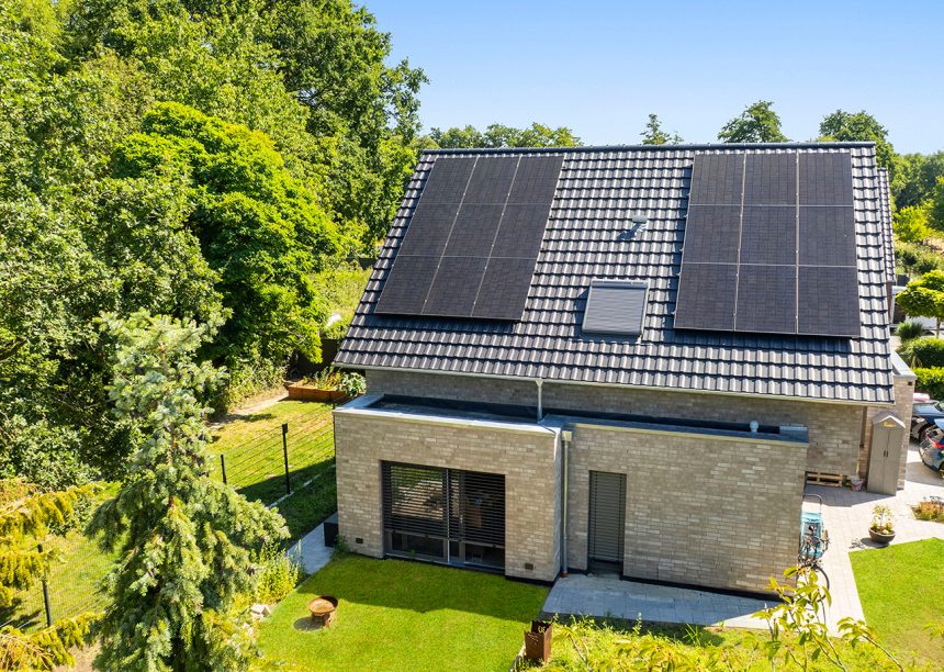 Reformziegel Z12v in samtschwarz auf hellem Backsteinhaus mit Satteldach in der Gesamtansicht per Drohne