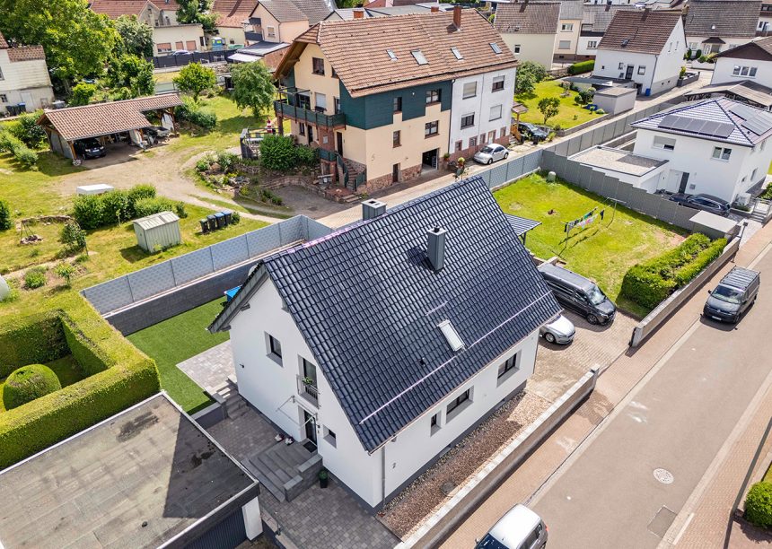 Flachdachziegel J13v von Jacobi Dachziegel in der Glasur marineblau auf inspirierendem Referenzobjekt per Drohne fotografiert von der Straßenseite fotografiert