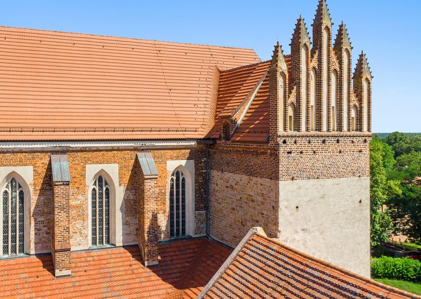 Top saniertes, denkmalgeschütztes Satteldach mit großem Unterschied zwischen sanierter und nichtsanierter Fläche. Havelländer Wellenbiber auf dem Dom Sankt Marien in Havelberg hier mit Giebelansicht