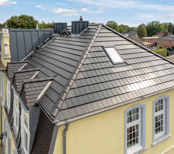 Hotel Villa Schneverdingen: energetische Sanierung mit Solarziegel Stylist-PV mit Biberschwanzziegeln an den Gauben.