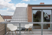 Reihenhaus mit minimalistischem Dach. Unser Flachziegel WALTHER Stylist in der Farbe edelgrau hier mit Dachterrasseneinblick.
